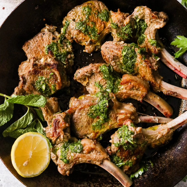 A platter of lamb with chimichurri sauce